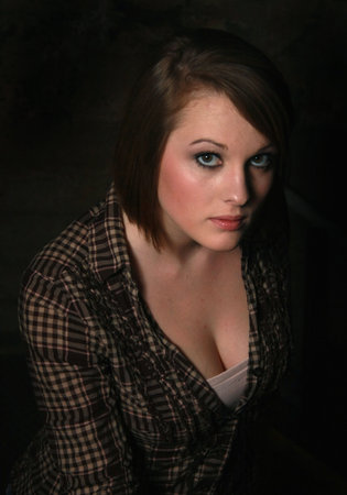A young woman sitting in dark shadowsの写真素材