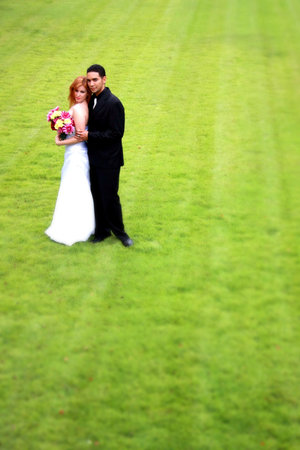 A bride and Groom stading on a green lawnの写真素材