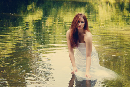 A redhead bride walking in a riverの写真素材
