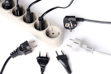 Many power supply plugs and only one free outlet isolated on whiteの写真素材