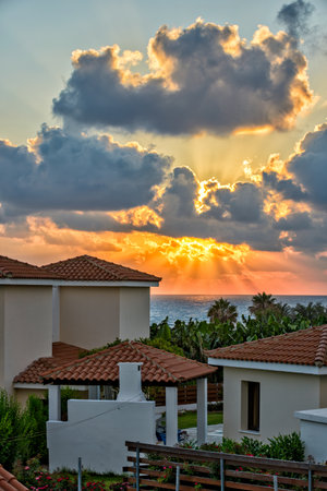 Sunset with sunbeams over luxurious holiday beach villas for rent on Cyprusのeditorial素材