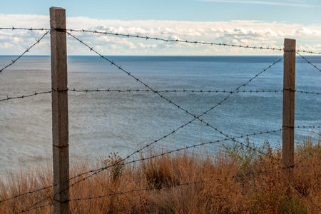 Barbed wire fence on sea coast