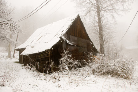 The old wooden cottage covered by whithe snowの写真素材