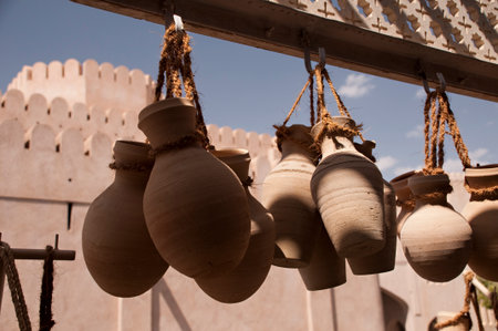 Hanging rough clay jars in front of arabic fortの写真素材
