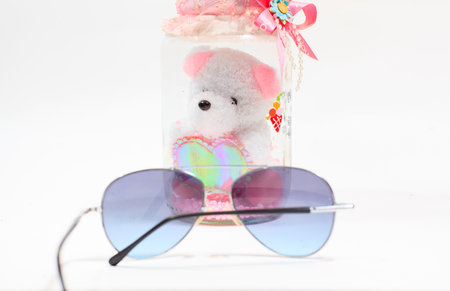 the doll bear and the sunglasses is the object on white blackgroundの写真素材
