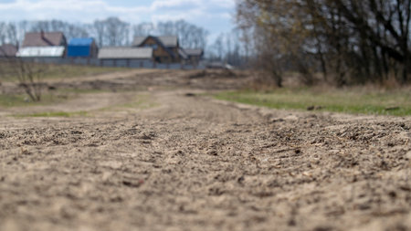 The village on the background of a forest sandy road. Summer landscape with a blur. Photo with place for text.の写真素材