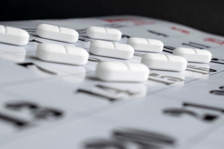 The calendar under the tilt where are the white pills on each date.の写真素材