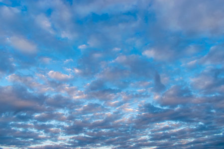 Dramatic blue sky and warm light clouds at sunrise or sunset on morning or evening time for background or backdrop.の写真素材