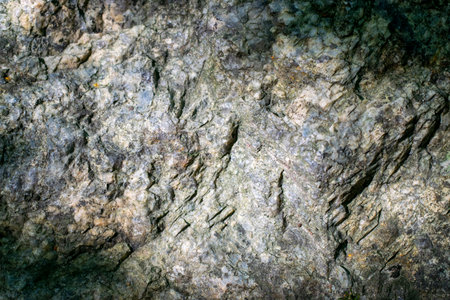 Raw granite rock texture background. Fragment of natural stone wall.