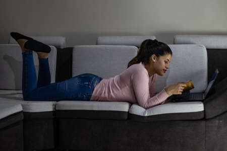 Young woman holding face mask at homeの写真素材