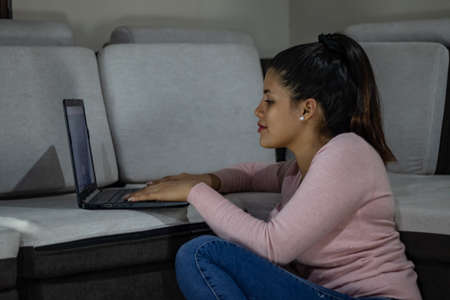 Young woman holding face mask at homeの写真素材