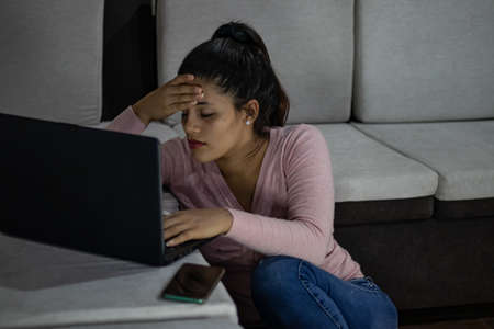 Stressed young woman studying online on her laptopの写真素材