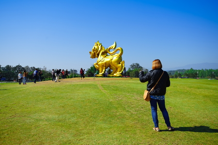 CHIANG RAI, THAILAND - December 23, 2017: Woman preparing to take a photo Singha figure in Singha park, Chiang Rai. This figure is a landmark of Singha park and famous place for Chiang Rai trip.のeditorial素材