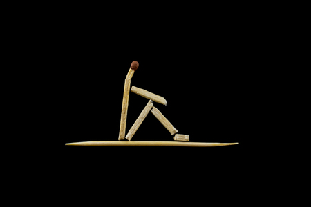 The sitting man. The figure of a man stylized by the matches on the black background. The objects are isolated and a clipping path is provided for easy extraction.の写真素材