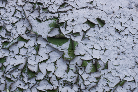 The old ruined painted stone wall of green and gray