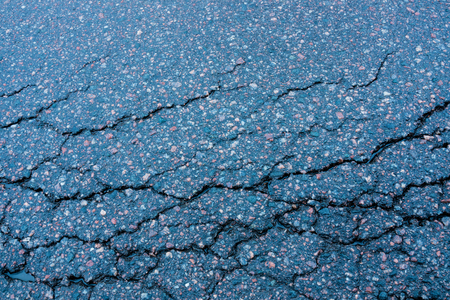 The old ruined asphalt pavement background texture waiting for repairの写真素材