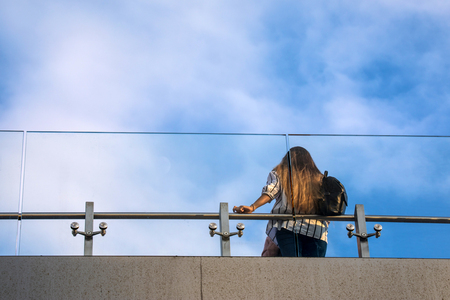 The view on the observation deck with the obstacle of steel and glass and the girl upwardsの写真素材