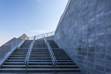The modern urban stone stairway with the steel guardrails in the sunny dayの写真素材