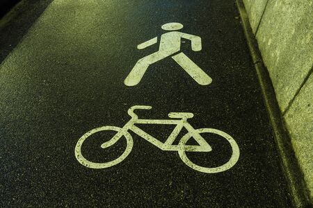 Bicycle and human symbols on asphalt