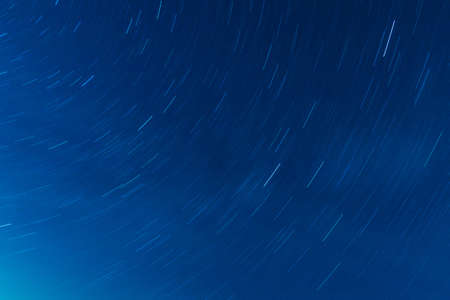 Background of round or circular star track or trajectory on the blue clear night sky. Symbol of...