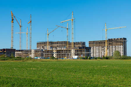 Cloudless landscape or scene of meadow with green grass and bushes with concrete modern building...
