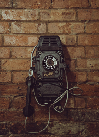 Old vintage telephone on the red brick wall.の写真素材