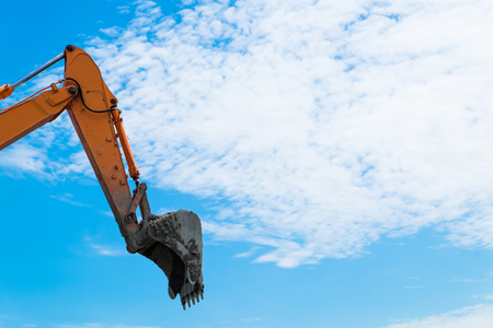 Mechanic arm of backhoe lift up on blue sky background