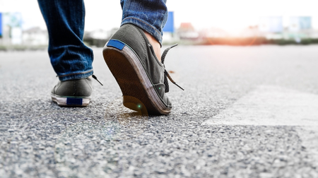Woman wear jeans and sneaker shoes walk on the roadの写真素材