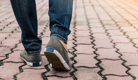 Woman wear jeans and sneaker shoes walk on the road