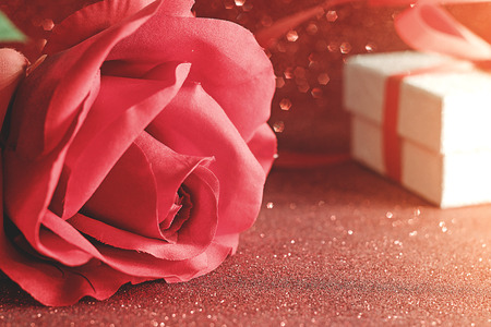 Red rose and glitter silver gift box with red ribbon placed on red glitter background,Valentines day celebration seasonal for loversの写真素材