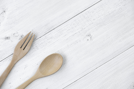 Wooden spoon and fork on white wooden background.の写真素材