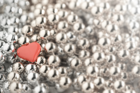 Little heart placed on silver and gold necklace.の写真素材