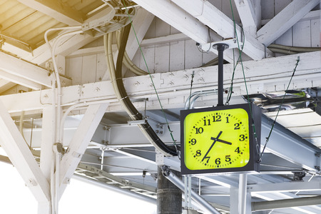 Clock with green face in train station.