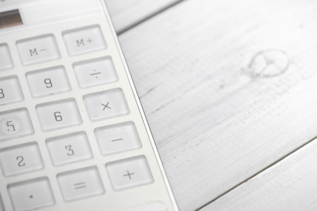 White calculator on white wooden backgroundの写真素材