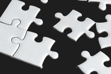 Pure white jigsaw puzzle seperated from group on black background