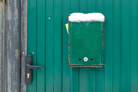 The mailbox is green on the metal gate of the house with a lock and a handle. Green backgroundの写真素材