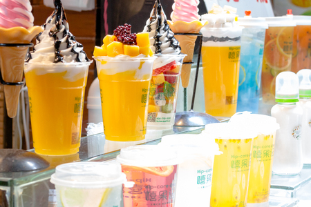 Section of freshly prepared ice cream and cold juices from tropical fruits in shop-window counter in the market of Chinese city Yangshuoのeditorial素材