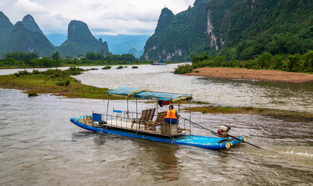 The man on a raft crosses the Li River known as well as Lijiang Riverの写真素材