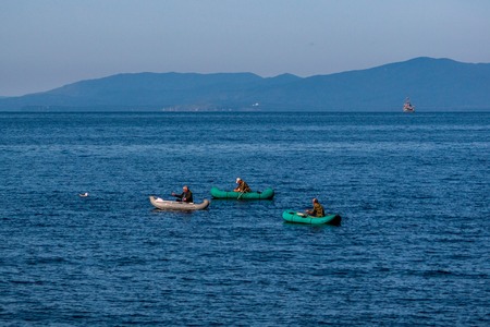 Fishermen on inflatable boats near the island Russian
