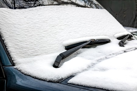 Snow on the front of the car. The first snow of November.の写真素材