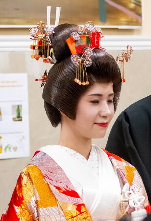 VLADIVOSTOK, RUSSIA - NOVEMBER 17, 2018: A Japanese girl actress in a national bride costume is photographed with visitors during the Fourth Festival of Japanese Culture in the Far Eastern city of Primorsky Krai, Russia, Vladivostok. Live Newsのeditorial素材