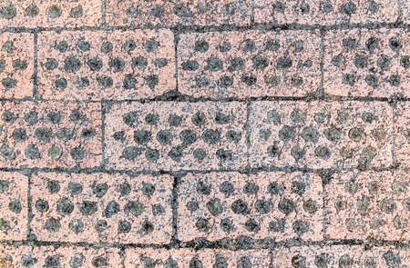 Background of paving stones with holes for the growth of grass in a Buddhist temple.