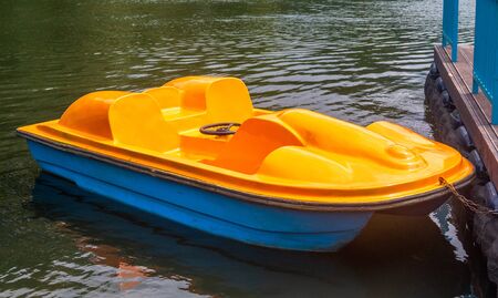 Yellow catamaran in the form of a pedal boat moored to the pierの写真素材