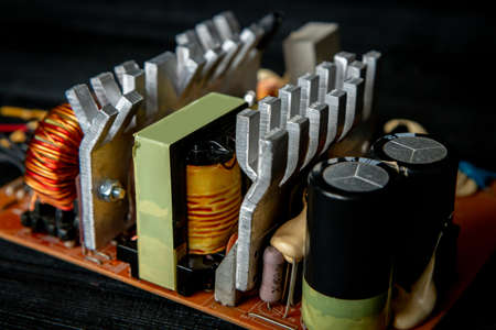 Part of pc power supply with radiator and electronic board with integrated stabilizers and filter capacitor with coils.の写真素材