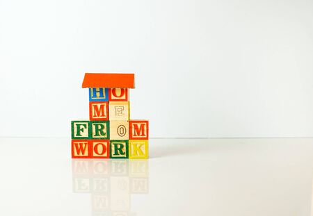Conceptual of work from home during lockdown directives during virus outbreak. Wooden alphabet cubes forming WORK FROM HOME. Focus on selective cubes only.の写真素材