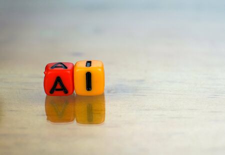 Conceptual of artificial intelligence in future information technology. 2 Colorful alphabet bead stacked on each other isolated on reflective surface. Focus on texts on beads. Others gradient blur.の写真素材
