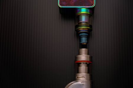Conceptual of recent uncertainty of health safety of e-cigarette. Isolated close-up of atomizer attached to mouthpiece and battery overの写真素材