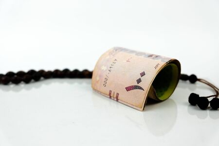 Image of saudi riyal banknote in SR100 denomination over reflective white. Focus on banknotes. Praye...