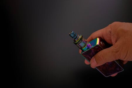 Conceptual of recent uncertainty of health safety of e-cigarette. Isolated close-up of atomizer attached to mouthpiece and battery overの写真素材