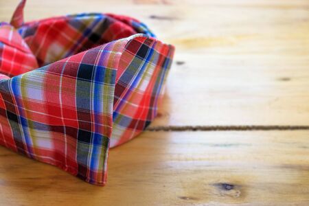 Image of tengkolok known as destar, traditional Malay male headgear on wooden surface. Made from cloth folded and tied in particular style. Worn in ceremony. Selective focus only.の写真素材